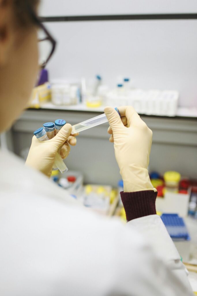 Scientist in lab holding test tube for COVID-19 research, indoors.
